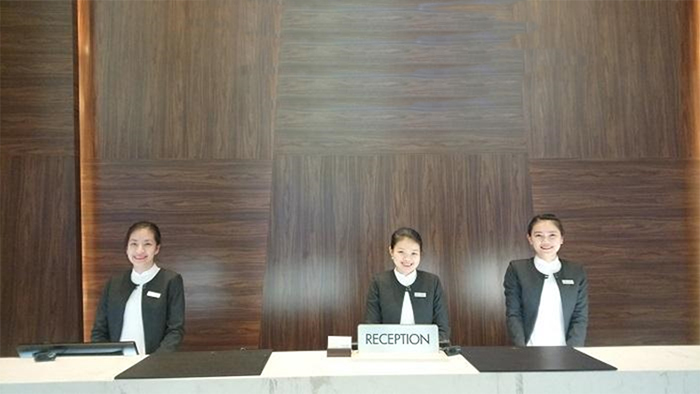 Hình ảnh tác phong chỉnh chu, nụ cười rạng rỡ của nhân viên lễ tân khách sạn.