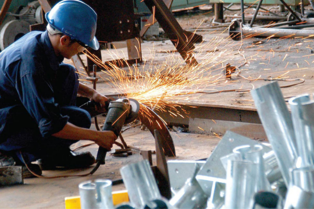 Thợ cơ khí đang tập trung hàn cắt kim loại tại xưởng sản xuất