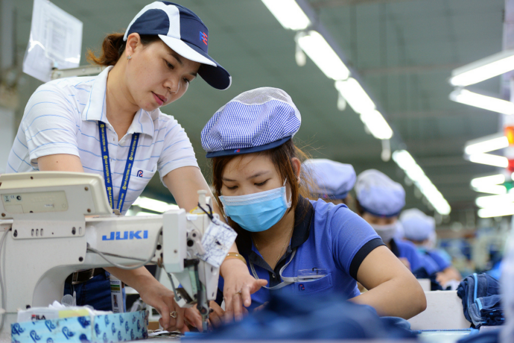 tổ trưởng hướng dẫn công nhân may