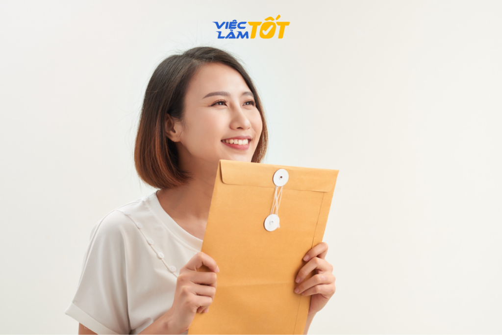 Nhà tuyển dụng đang mỉm cười khi đọc một lá thư ứng tuyển ấn tượng