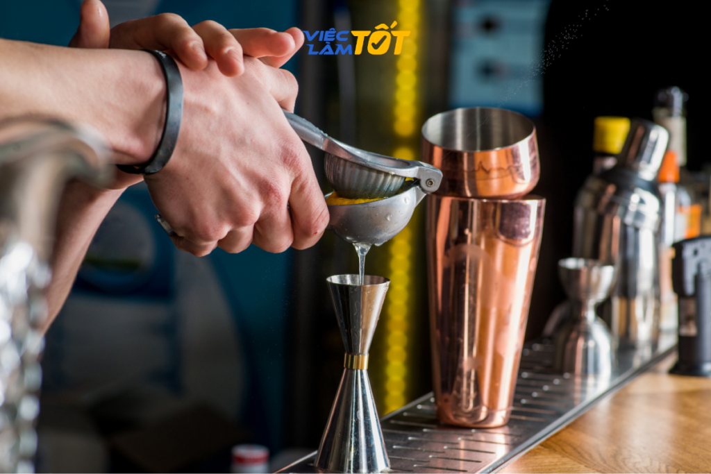 Trưởng ca pha chế hướng dẫn kỹ thuật cho nhân viên mới tại quầy bar