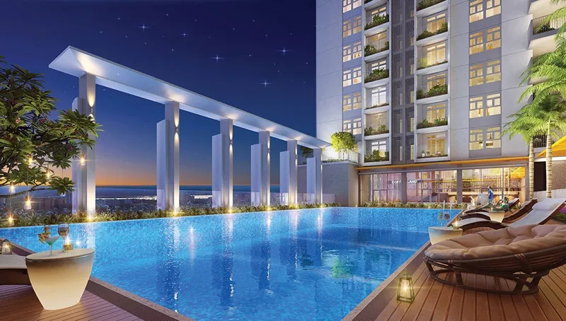 Hồ bơi sang trọng trên tầng cao với đèn chiếu sáng và view thành phố về đêm.