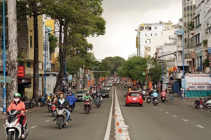 Đường Lê Văn Duyệt, quận Bình Thạnh, TP.HCM với xe máy và ô tô lưu thông đông đúc giữa hàng cây xanh và dãy nhà phố.