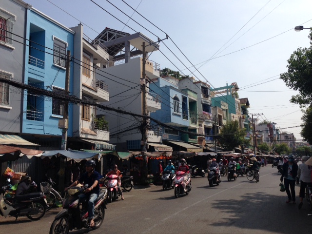 Đường Nguyễn Văn Đậu, quận Bình Thạnh, TP.HCM với xe máy lưu thông và dãy nhà phố kinh doanh hai bên.