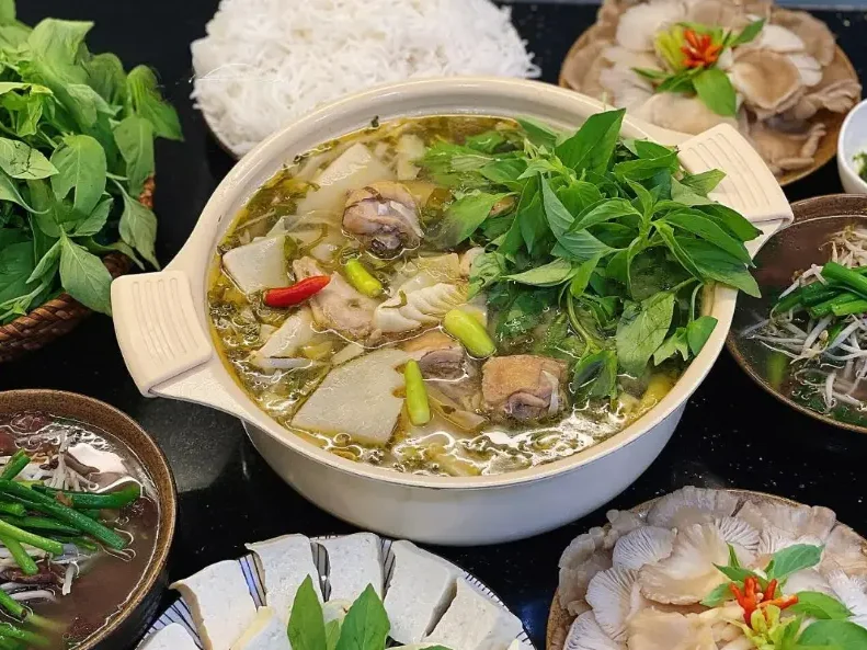 Hình ảnh lẩu gà lá é bốc khói nghi ngút – món ăn trưa Đà Lạt nổi bật.