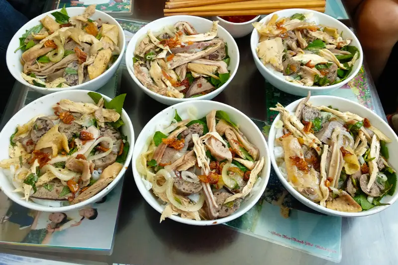 Đĩa bánh ướt lòng gà Đà Lạt đầy đặn với hành phi và rau thơm.
