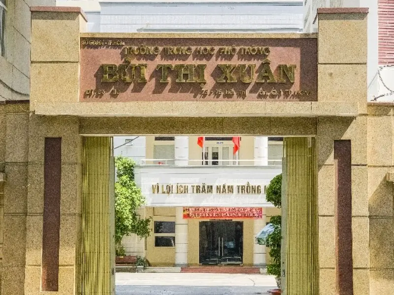 Cổng chính Trường THPT Bùi Thị Xuân với biển tên nổi bật và khẩu hiệu giáo dục.