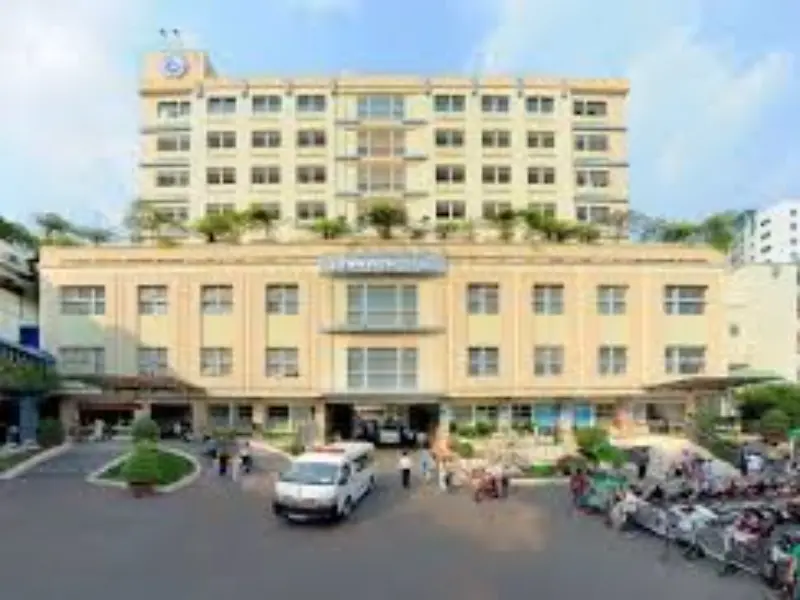 Bệnh viện Từ Dũ ở đâu? Nên cân nhắc khu vực cư trú nào gần đó? Mặt tiền chính của Bệnh viện Từ Dũ ở đâu tại TP.HCM, với tòa nhà nhiều tầng, khuôn viên rộng và xe cứu thương đậu trước cổng.