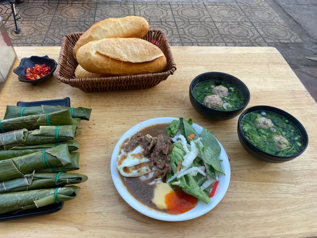 Bánh mì xíu mại – món ăn sáng Đà Lạt được phục vụ kèm nước dùng, chả cây và rau sống.