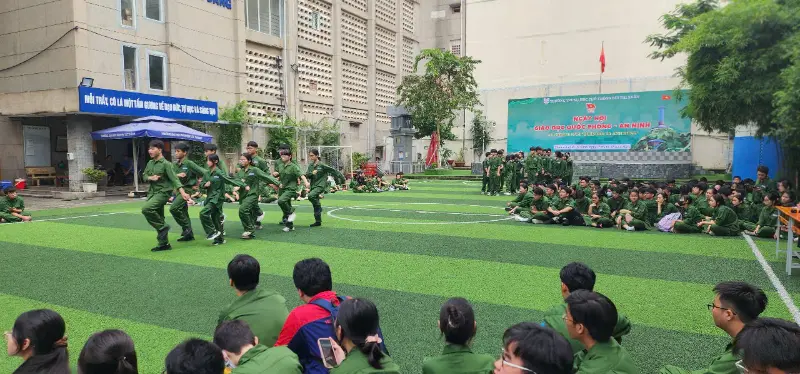 Học sinh Trường THPT Bùi Thị Xuân tham gia Ngày hội Giáo dục Quốc phòng – An ninh trên sân trường, mặc đồng phục xanh quân sự và tham gia các hoạt động tập thể.