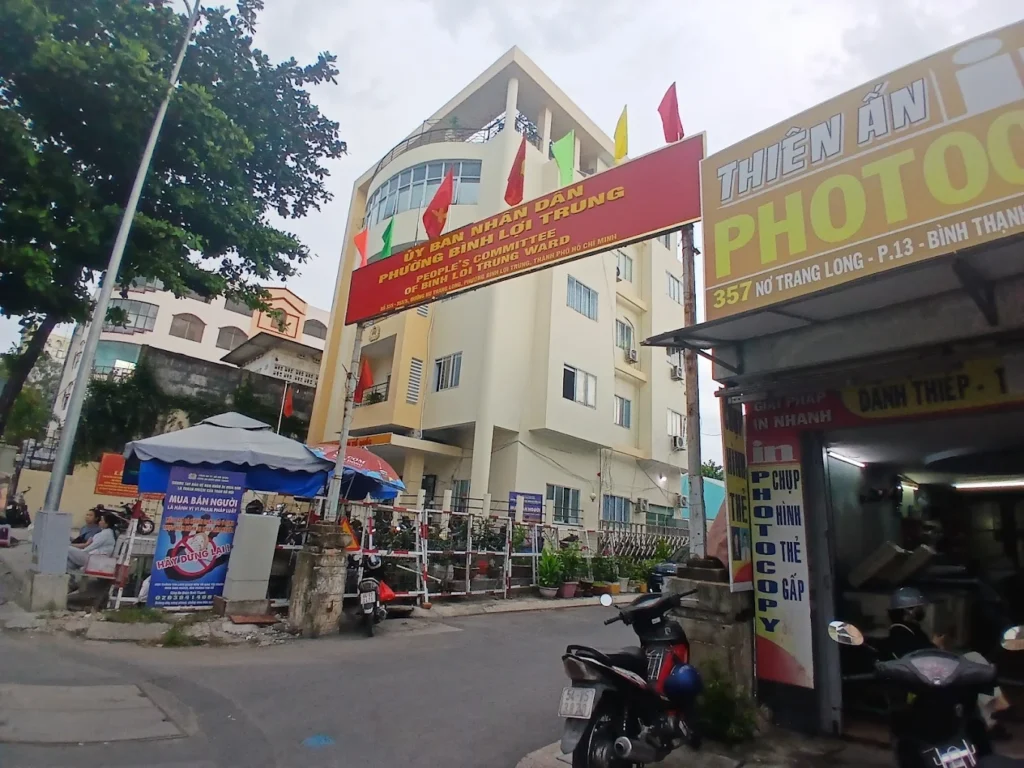 Mặt tiền UBND phường Bình Lợi Trung với bảng tên đỏ và ghế ngồi đặt trước sân