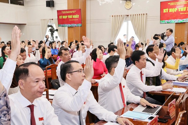 Các đại biểu tham gia kỳ họp HĐND tỉnh Đồng Nai giơ tay biểu quyết trong hội trường