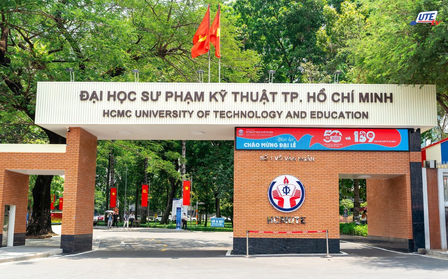 Cổng chính Trường Đại học Sư phạm Kỹ thuật TP.HCM với hàng cây xanh và cờ đỏ phía trước