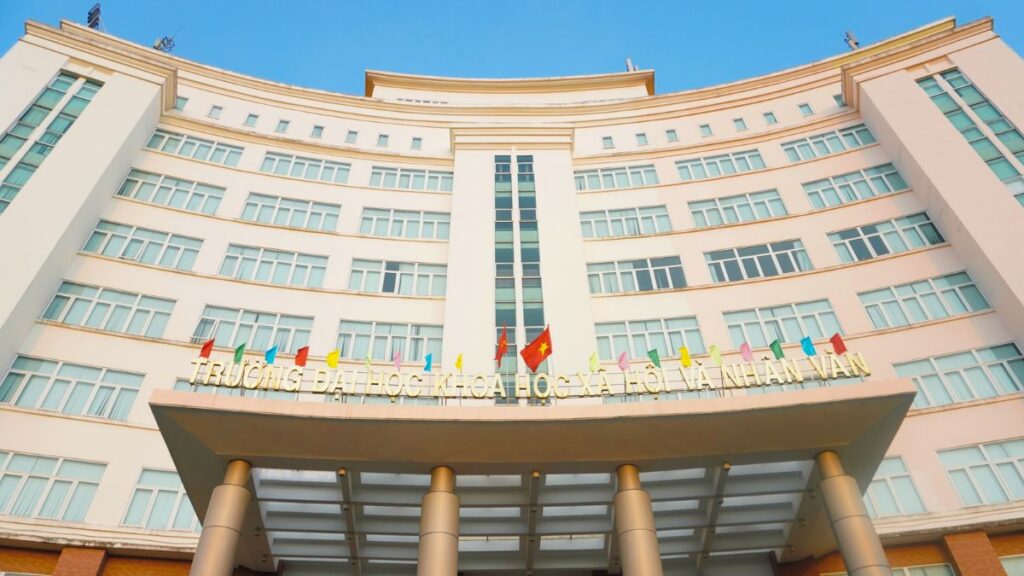 Mặt tiền Trường Đại học Khoa học Xã hội và Nhân văn với kiến trúc cong hiện đại và cờ trang trí