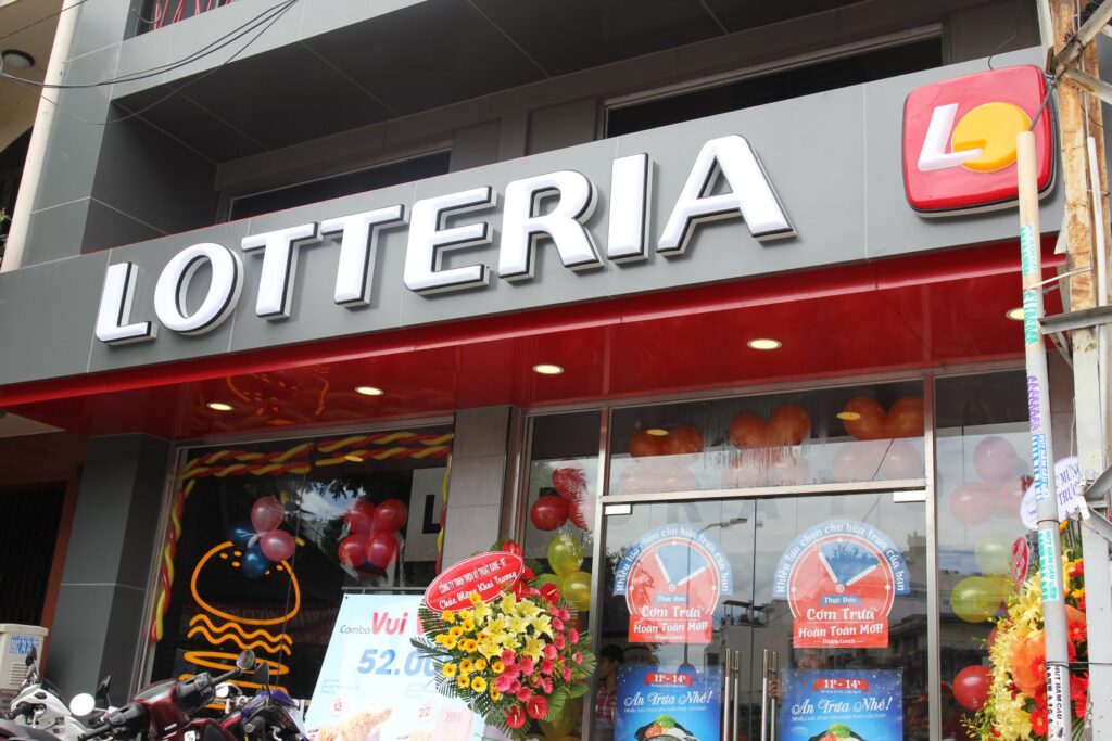 Mặt tiền cửa hàng thức ăn nhanh Lotteria trên đường Xô Viết Nghệ Tĩnh với logo màu đỏ đặc trưng và hệ thống cửa kính suốt nhìn vào bên trong.