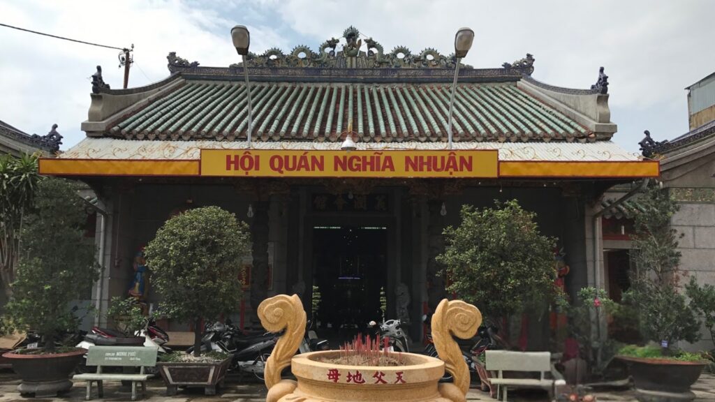 Mặt tiền Miếu Ông Quan Đế với tường sơn màu đỏ đặc trưng, mái ngói âm dương và các đèn lồng treo trước cửa.