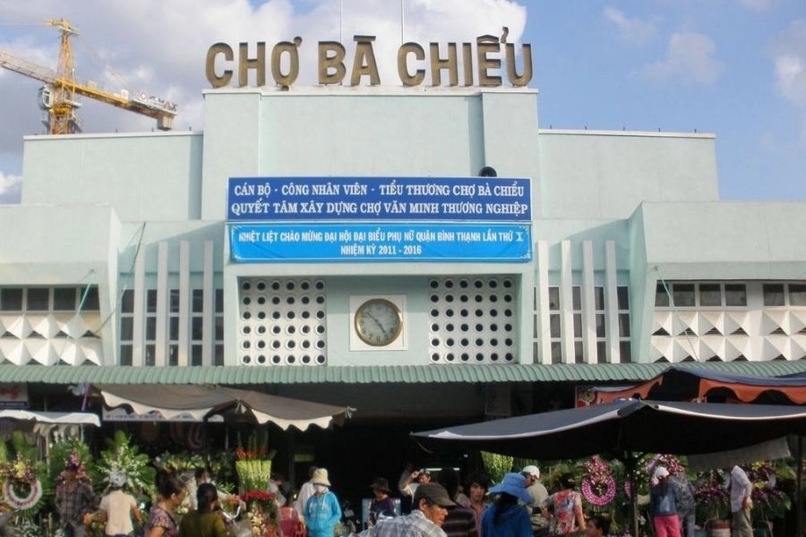 Quang cảnh nhộn nhịp phía trước nhà lồng Chợ Bà Chiểu với biển hiệu lớn