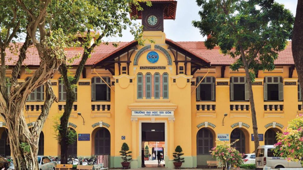 Tòa nhà cổ kính Trường Đại học Sài Gòn với mặt tiền vàng và hàng cây lớn phía trước