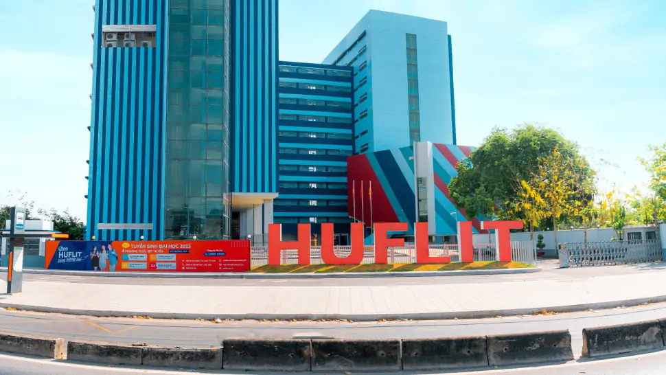 Tòa nhà chính Trường Đại học Ngoại ngữ - Tin học TP.HCM HUFLIT với logo đỏ nổi bật phía trước
