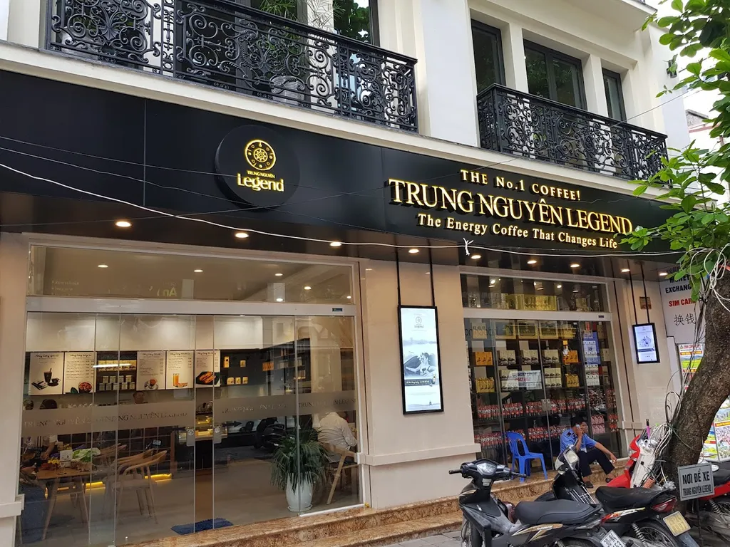 Không gian bên trong Trung Nguyên Legend Coffee nổi bật với các kệ sách đổi đời, bàn ghế gỗ đệm da lịch sự và hệ thống ánh sáng dịu nhẹ.