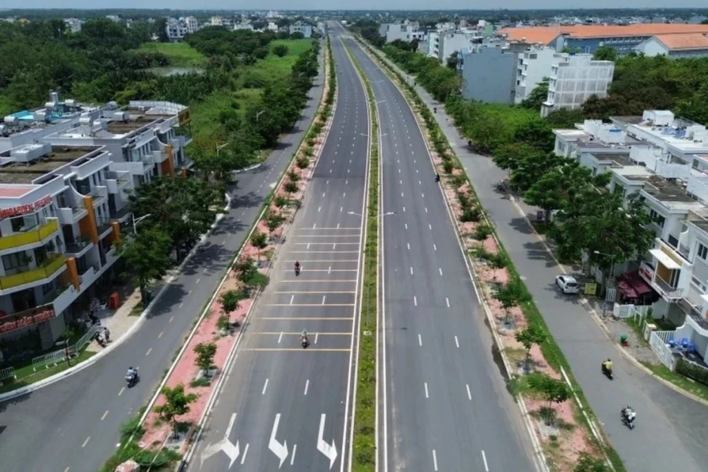 Công trường thi công trải nhựa và lắp đặt hạ tầng tại phân đoạn xây mới đường song hành Quốc lộ 50 mở rộng