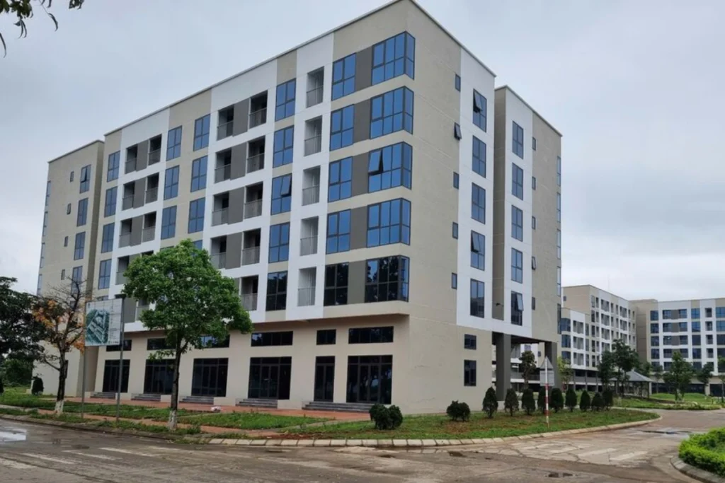 Tổ hợp chung cư nhà ở xã hội thấp tầng với thiết kế ô kính hiện đại và khuôn viên cây xanh xung quanh thoáng mát