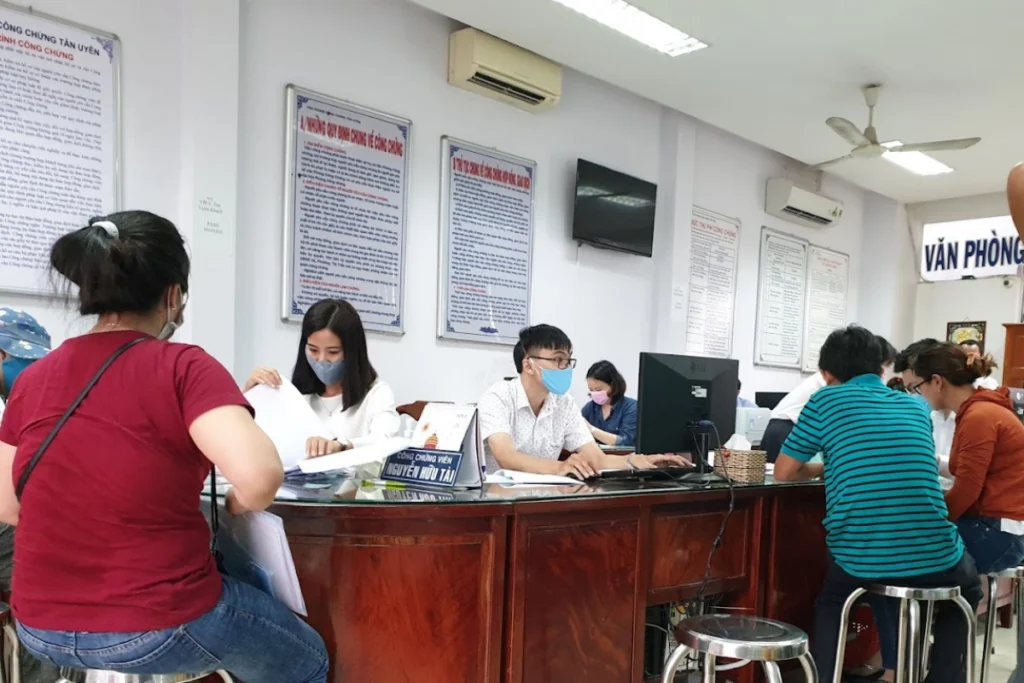 Người dân đang được công chứng viên hướng dẫn kiểm tra tài liệu tại bàn làm việc