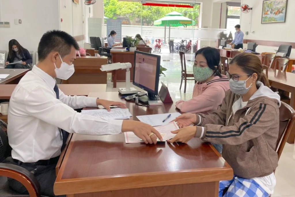 Công chứng viên trực tiếp kiểm tra giấy chứng nhận quyền sử dụng đất và hướng dẫn người dân ký hợp đồng giao dịch
