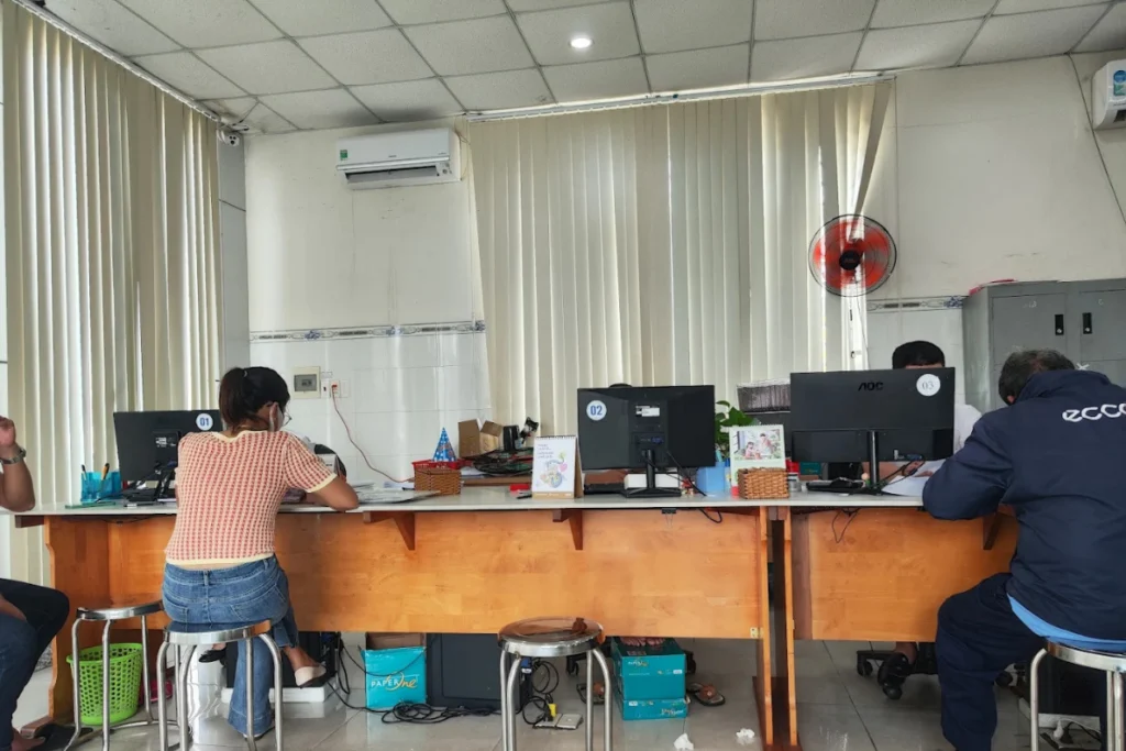 Người dân ngồi tại các quầy nghiệp vụ để chuyên viên kiểm tra hồ sơ, đánh máy nội dung hợp đồng công chứng