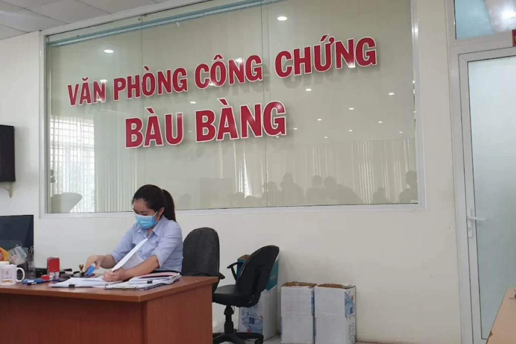 Chuyên viên đang hoàn thiện hồ sơ và đóng dấu chứng thực cho khách hàng tại Văn phòng công chứng Bàu Bàng