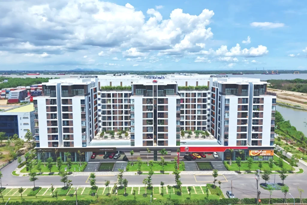 Các tòa nhà chung cư cao tầng hiện đại đan xen với khuôn viên cây xanh và bãi cỏ rộng lớn, hình ảnh minh họa cho thắc mắc người đã có nhà có được mua nhà ở xã hội không