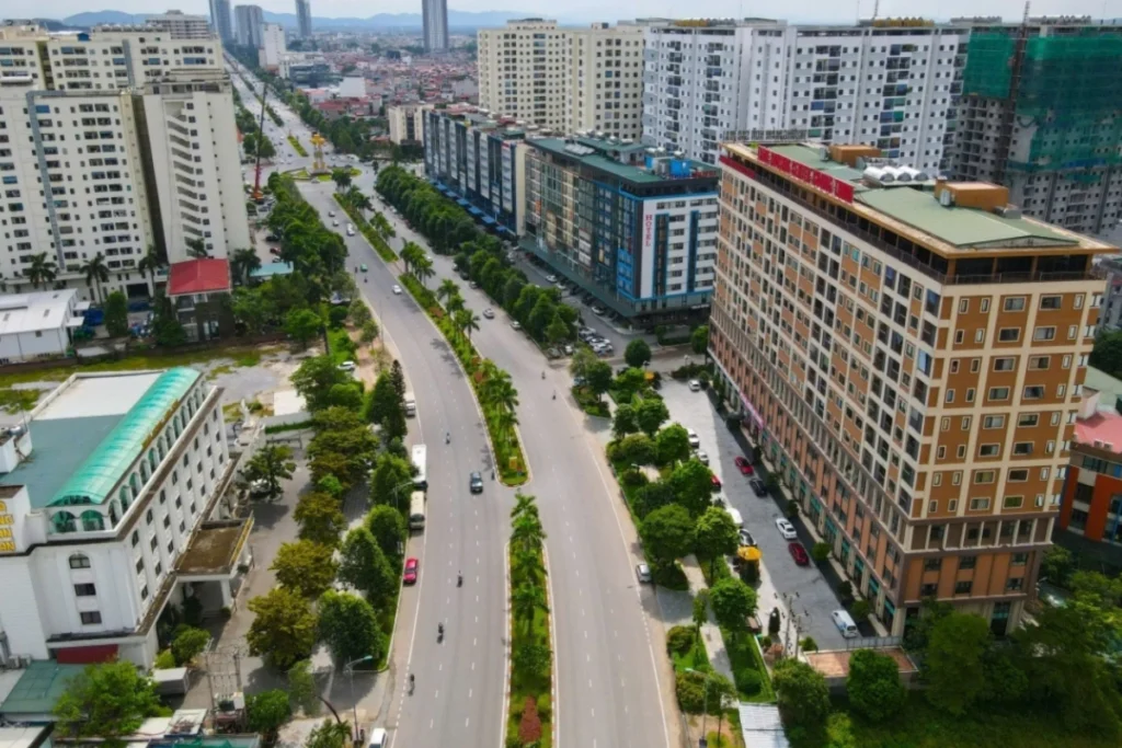 Góc chụp từ trên cao toàn cảnh một đại lộ lớn nhiều làn xe chạy qua trung tâm thành phố Bắc Ninh, dải phân cách giữa trồng cây xanh mướt