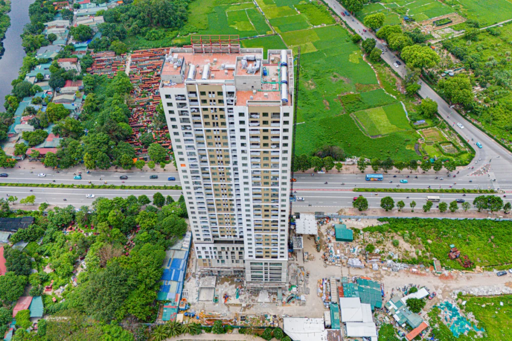 Góc nhìn toàn cảnh từ trên cao một tòa tháp chung cư cao tầng đang trong giai đoạn hoàn thiện thi công