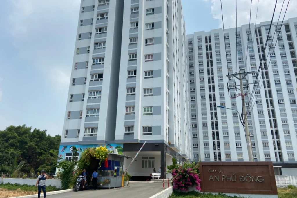 Góc nhìn cận cảnh từ dưới lên một block tòa nhà cao tầng của dự án cao ốc An Phú Đông sơn màu xám trắng thanh lịch