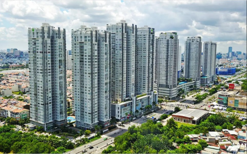 Toàn cảnh các tòa tháp chung cư cao tầng hiện đại tại Quận 7 nằm dọc theo đại lộ lớn với nhiều mảng xanh, minh họa cho câu hỏi chung cư quận 7 hay quận 8 nên mua loại nào