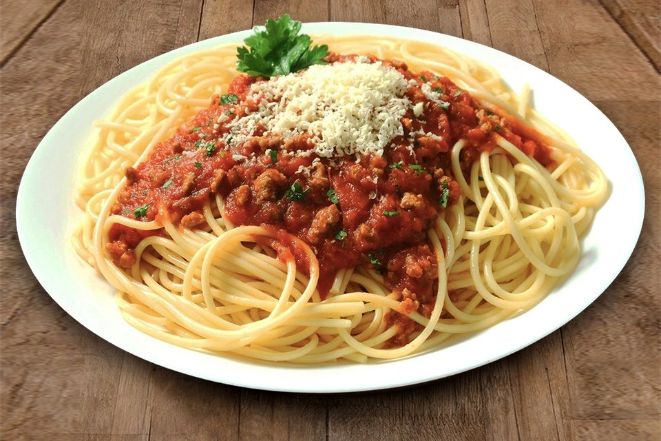Đĩa mỳ Ý spaghetti sốt cà chua đậm đà trang trí lá húng tây và phô mai bào