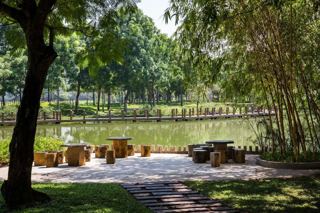 Khuôn viên công viên xanh mát rợp bóng cây cổ thụ có hồ nước trung tâm và các bộ bàn ghế đá