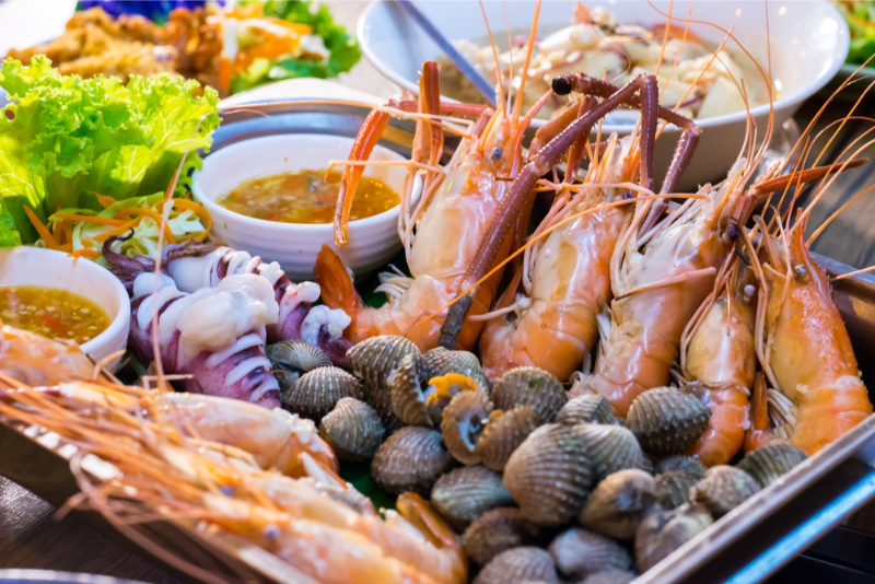 Khay hải sản luộc gồm tôm càng luộc mực ống hấp và sò huyết đi kèm các chén muối ớt xanh