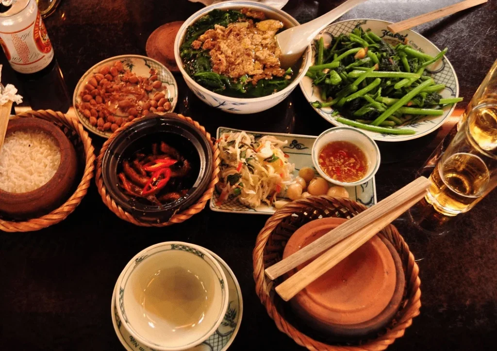 Mâm cơm niêu truyền thống với cá kho tộ, canh cua mồng tơi, rau xào, cà pháo và đậu hũ