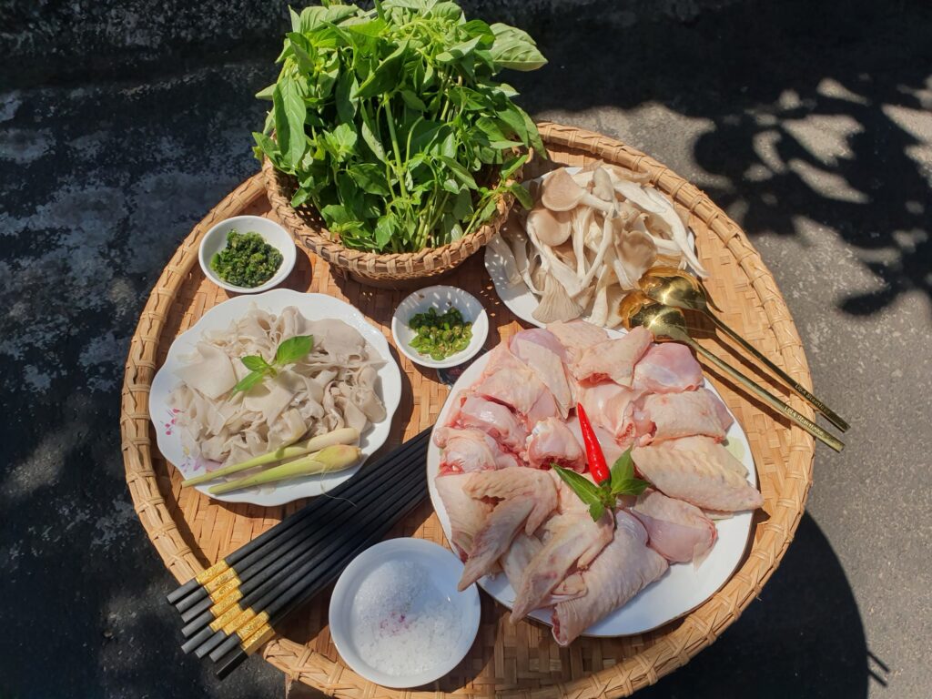 Top 10 quán ăn ngon phường Vườn Lài đáng ghé thử một lần Mẹt nguyên liệu gà ta tươi sống nấm tươi và rổ lá é trắng để nấu lẩu