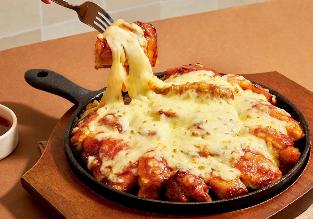 Chảo gà sốt cay phủ phô mai Mozzarella kéo sợi tan chảy vàng ươm trên chảo gang nóng hổi