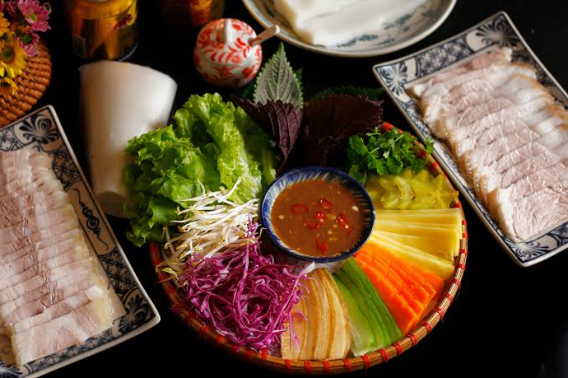 Mẹt thịt ba chỉ luộc xắt lát mỏng ăn kèm bánh tráng dẻo, rau rừng và chén mắm nêm tỏi ớt