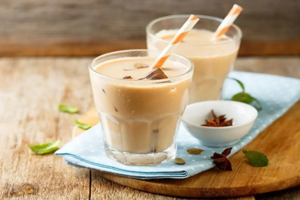 Hai ly trà sữa mát lạnh với ống hút giấy sọc cam trắng đặt trên khăn trải bàn xanh tại quán cafe phường Hoà Bình