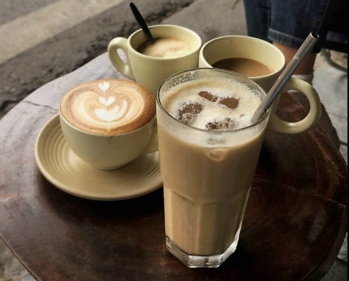 Các ly cà phê sữa đá, cà phê latte tạo hình nghệ thuật và cà phê trứng trên bàn gỗ