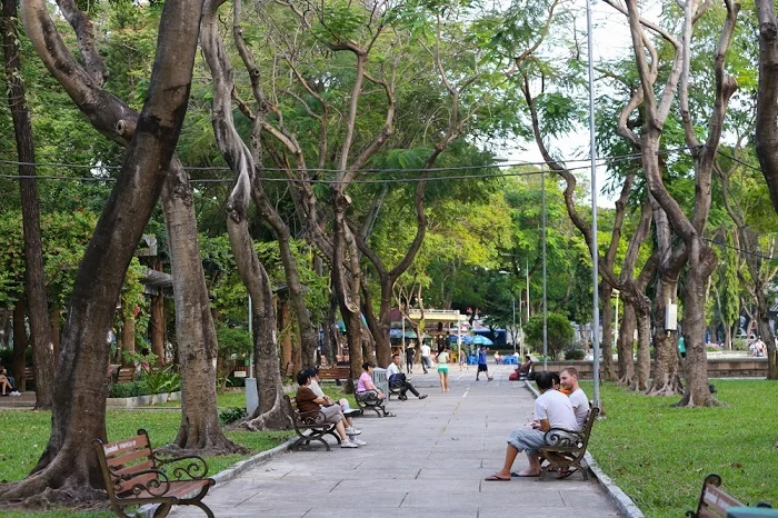 Con đường rợp bóng cây xanh mát và người dân thư giãn tại công viên Lê Thị Riêng
