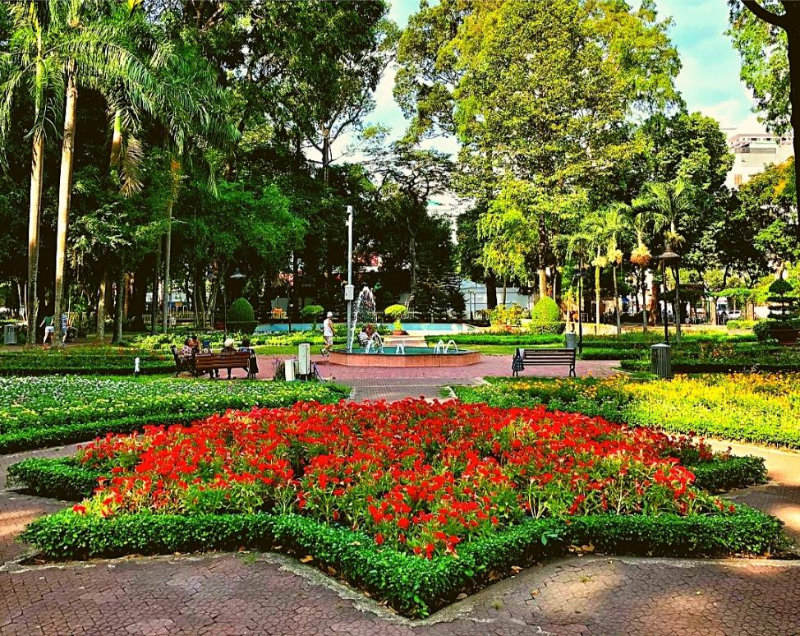 Không gian công viên cây xanh thoáng mát với thảm hoa đỏ rực rỡ