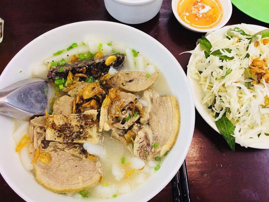 Chơi gì ở phường Minh Phụng? Top 5 địa điểm vui chơi nổi bật Bát bánh canh vịt nóng hổi với sợi bánh canh trắng, miếng thịt vịt luộc thái lát, huyết vịt và hành phi thơm phức. Bên cạnh có đĩa rau sống và bát nước chấm