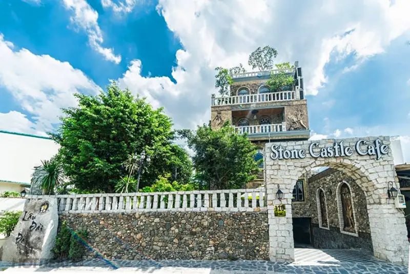 Stone Castle Cafe, một tòa nhà nhiều tầng được xây dựng bằng đá theo phong cách lâu đài cổ kính, với một cổng vòm lớn dẫn vào.Một điểm đến độc đáo cho câu hỏi "chơi gì ở phường Tân Phú"