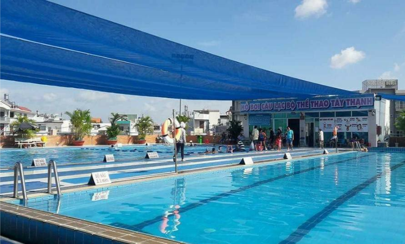 Hồ bơi ngoài trời xanh mát có mái che lưới xanh tại Câu lạc bộ Thể thao Tây Thạnh