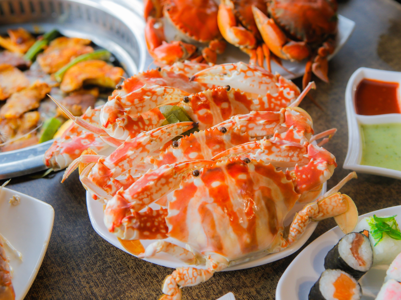 Đĩa ghẹ hấp màu cam rực rỡ tươi ngon cùng sushi và đồ nướng